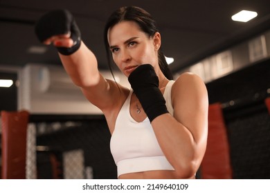 Young fitness woman with hands in black bandages posing in fighting stance - Powered by Shutterstock