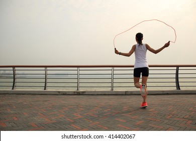 Young Fitness Woman Jumping Rope At Seaside