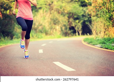 Young Fitness Woman Legs Running At Forest Trail 