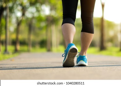 Young Fitness Woman Legs Walking In The Park Outdoor, Female Runner Running On The Road Outside, Asian Athlete Jogging And Exercise On Footpath In Sunlight Morning. Sport,healthy And Wellness Concepts