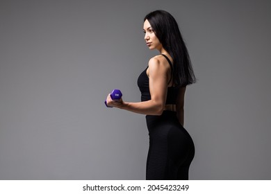 Young Fitness Woman Lifting Dumbell On Gray Background