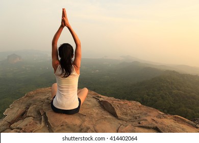 young fitness woman practice yoga at mountain peak cliff - Powered by Shutterstock