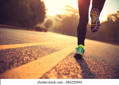 young fitness woman runner athlete running at road - Shutterstock ID 385235995