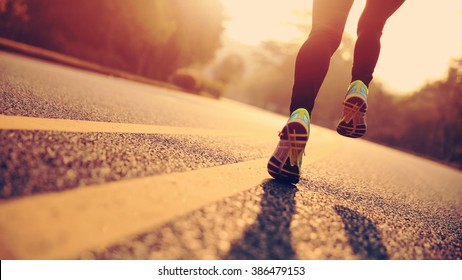 young fitness woman runner athlete legs running at road - Shutterstock ID 386479153