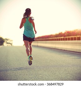 young fitness woman runner running on seaside bridge - Shutterstock ID 368497829