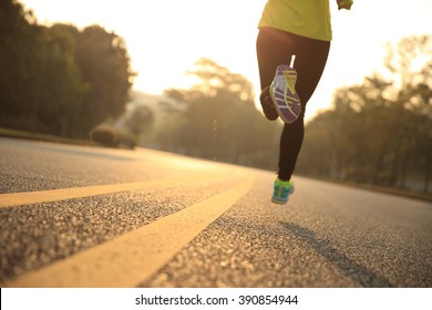young fitness woman runner running on sunrise road - Shutterstock ID 390854944