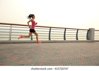 young fitness woman runner running at seaside - Shutterstock ID 415720747