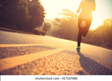 young fitness woman runner running on road - Shutterstock ID 417567088