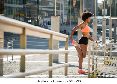 Young fitness woman runner stretching legs before run - Powered by Shutterstock