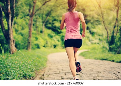 young fitness woman running at forest trail  - Powered by Shutterstock