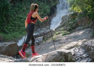 Young Fitness Woman Running At Forest Trail On Waterfall Background