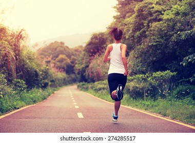 young fitness woman running at forest trail - Powered by Shutterstock