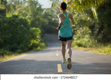 Young Fitness Woman Running On  Tropical Forest Trail