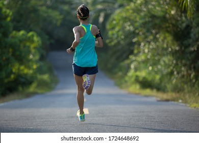 Young Fitness Woman Running On  Tropical Forest Trail