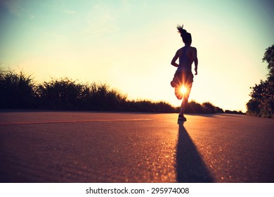 young fitness woman running on sunrise seaside trail - Shutterstock ID 295974008