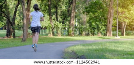 young fitness woman running in the park outdoor, female runner walking on the road outside 