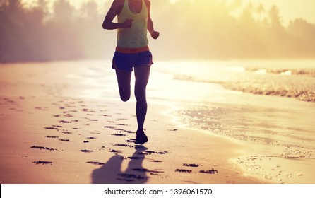 Young Fitness Woman Running At Sunrise Beach 