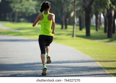 Young Fitness Woman Running At Tropical Park
