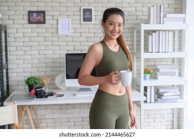 Young fitness woman in sportswear having a cup of coffee after exercising at home, Healthy and Lifestyles.