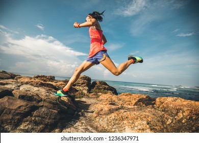 Young Fitness Woman Trail Runner Running To Rocky Mountain Top On Seaside