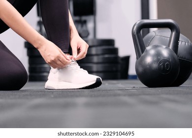 Young fitness woman tying shoelaces in gym fitness concept