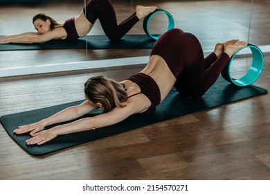 young flexible girl doing gymnastics, flexibility and stretching with yoga wheel - Powered by Shutterstock