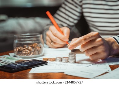 Young Focused Man Paying Bills Online On Computer Laptop Paper Document On Table Worried About High Bill Invoice, Overdue Debt, Expenses, Expenditures Household Finances Taxes Payment On Calculator