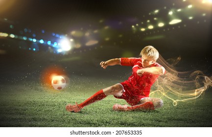 Young Football Player On Stadium Doing Slide Tackle