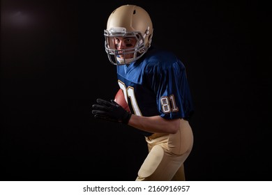 Young football player in running action on a dark background - Powered by Shutterstock