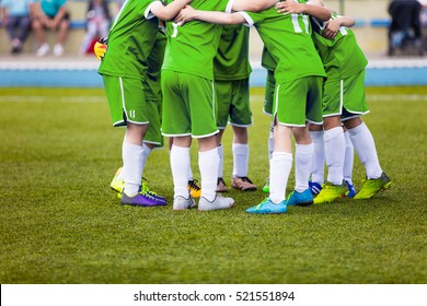 Young football soccer players in green sportswear. Young sports team on pitch. Pep talk before the final match. Soccer school tournament. Children on sports field.
