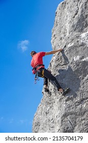 A Young Free Climber Climbs On A Cliff