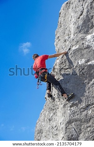 A Young free climber climbs on a cliff
