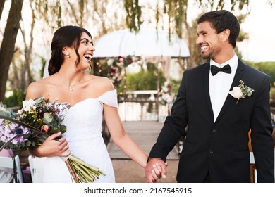 Young, free and in love. Shot of a happy newlywed young couple holding hands together outdoors on their wedding day. - Powered by Shutterstock