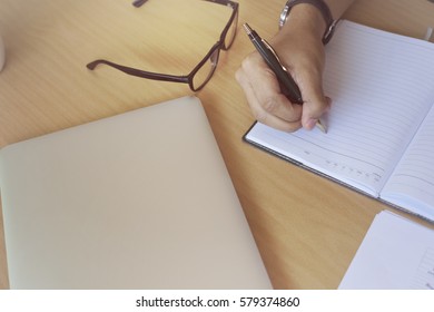 Young freelancer work at the cafe, making notes