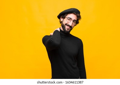 Young French Artist Man Laughing Cheerfully And Confidently With A Casual, Happy, Friendly Smile Against Orange Wall