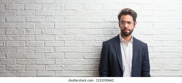 Young friendly business man doubting and confused, thinking of an idea or worried about something