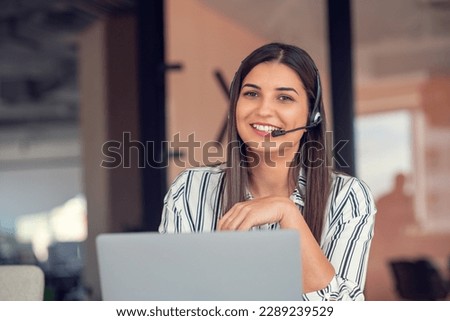 Young friendly operator woman agent with headsets working in a call centre.