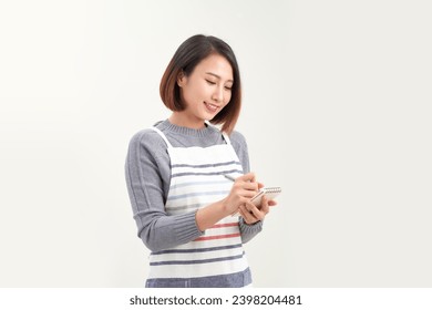 young friendly waitress in apron making notes in notepad, she smiling while taking order - Powered by Shutterstock