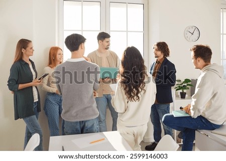 Young friends, business coworkers office group talk, students using laptop online at work, discussing project learning strategy, planning common startup, studying together, share opinions and ideas
