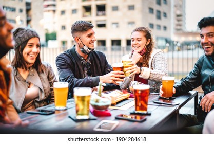 Young Friends Drinking Beer Pint With Open Face Mask - New Normal Lifestyle Concept With Milenials Having Fun Together Talking At Outside Brewery Bar - Warm Filter With Focus On Left Central Guy