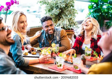 Young Friends Drinking Mojito Cocktails At Fancy Pub Restaurant - Life Style Concept With Multicultural People Having Fun Together On Happy Hour At Trendy Bar - Vivid Filter With Focus On Central Guy