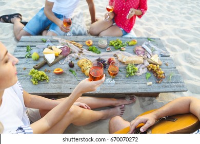 Young Friends Drinking Rose Wine On Summer Beach Picnic. Summer Vacation And Party Concept