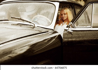 Young Friends Driving Retro Car In The Rain.