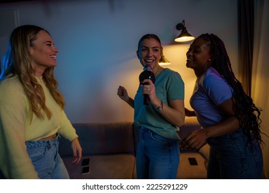 Young Friends Enjoying Karaoke Night Together At A Friends House, Singing And Dancing Together