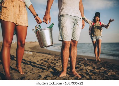 Young friends enjoying a walk on the beach party on a sunny day holding beer. - Powered by Shutterstock