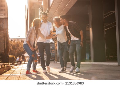 Young friends hang out on the city street.They go for walks together and have fun in the city downtown. - Shutterstock ID 2131856983