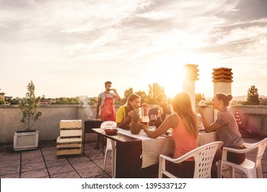 Young Friends Having Barbecue Party At Sunset On Penthouse Patio - Happy People Doing Bbq Dinner Outdoor Cooking Meat And Drinking Wine - Focus On Left Woman Face - Food, Fun And Friendship Concept 