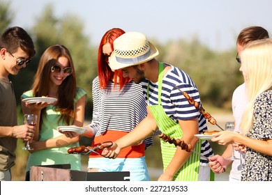 Young friends having barbecue party, outdoors - Powered by Shutterstock