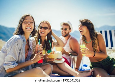 Young friends having fun at the beach on a sunny day. Party time. - Powered by Shutterstock