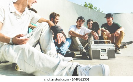 Young friends having fun at city skate park at sunset - Happy skaters laughing and listening music with vintage stereo - Extreme sport, friendship, youth, lifestyle concept - Focus on right man face - Powered by Shutterstock